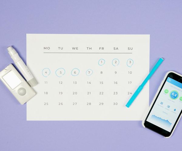 A calendar with a highlighted date and a yoga mat next to it, symbolizing a daily routine.