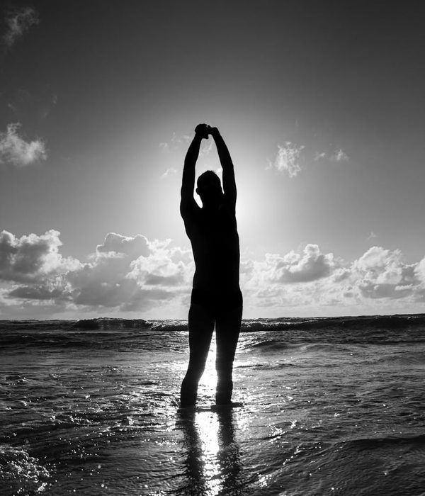 Silhouette of a person stretching at sunrise, symbolizing renewed energy.